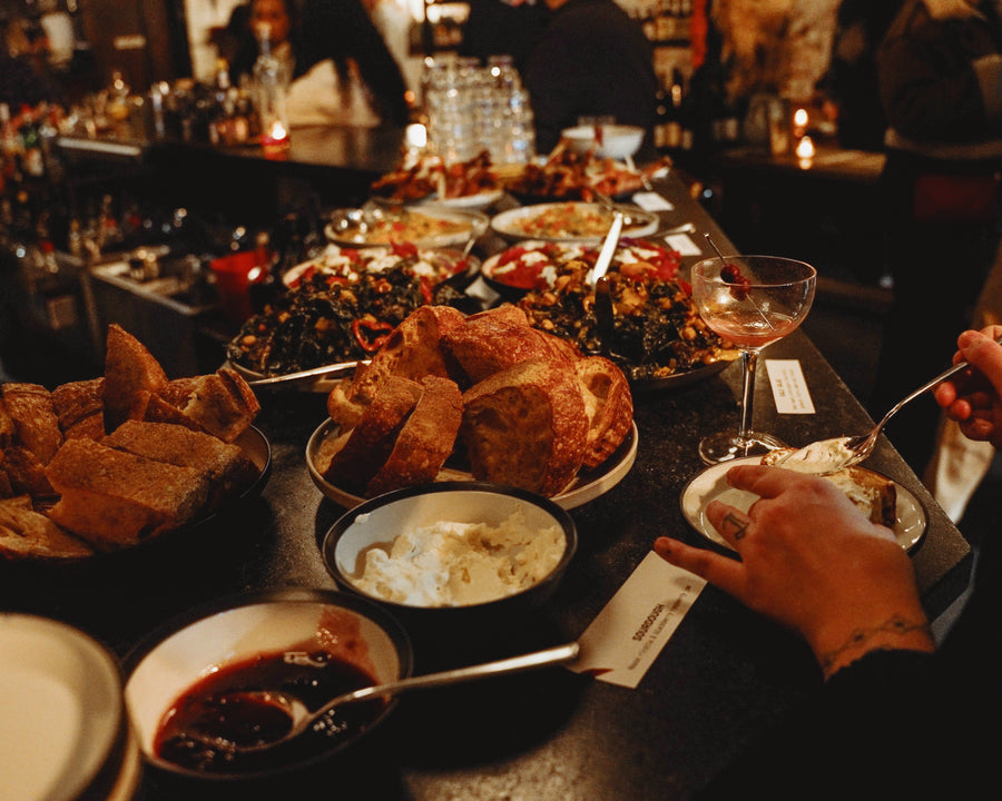 A party spread of bread, dips and plates at Field