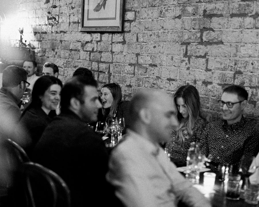 A table of friends laughing at Field
