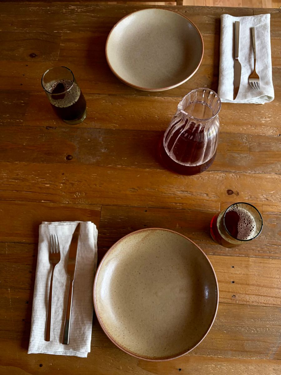 The decanter full of red wine on a set table, seen from above